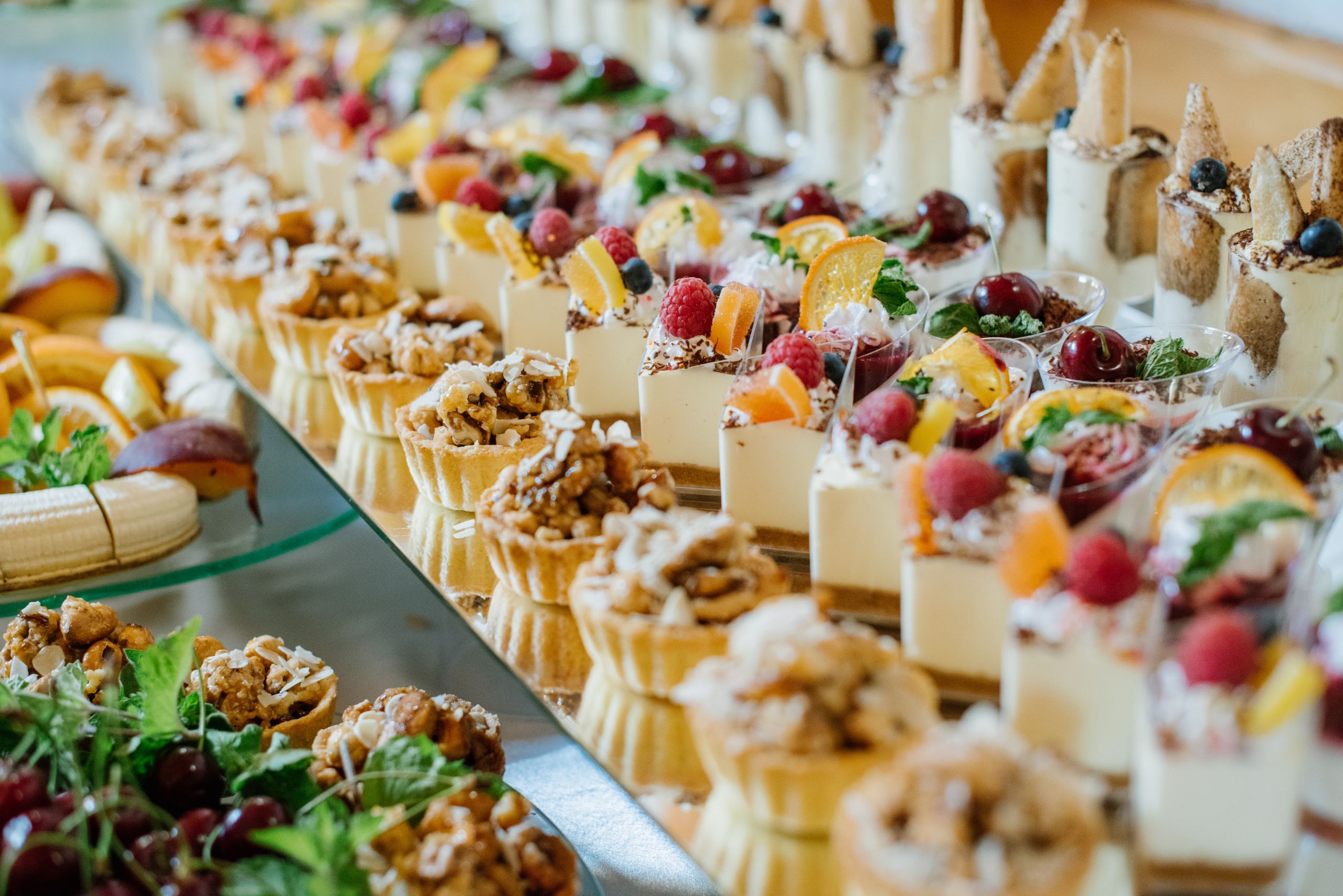 Sweet dessert cakes and cupcakes and jellys on the candy bar at the celebration